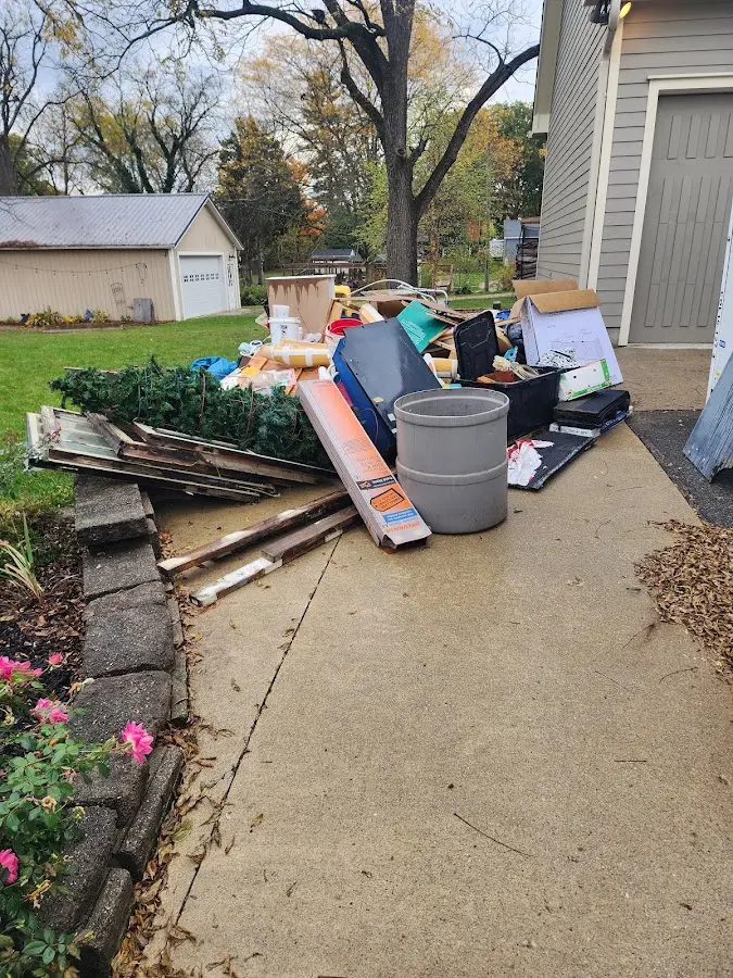 Dumpster being loaded with debris for Roofing Dumpster Rental in Bedford